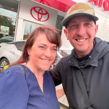 Justin and a smiling customer in front of Toyota of Tacoma